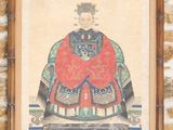une vieille photo d'un homme vêtu d'une robe rouge, assis sur une chaise