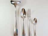 a spoon, fork, spoon and spoon rest on a table