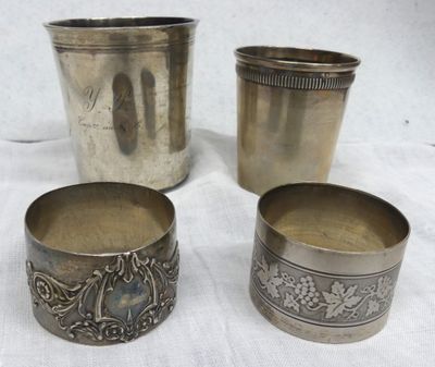 three silver cups with designs on them sitting on a white cloth