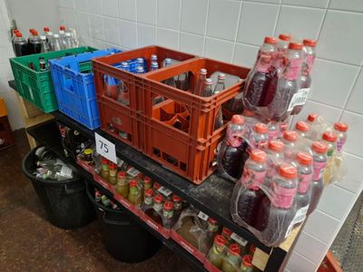 de nombreuses bouteilles de soda sur une étagère dans une pièce