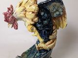 a figurine of a rooster with a flower in its beak
