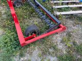 a tractor with a tire attached to it in the grass