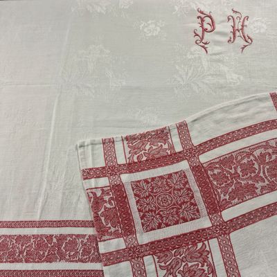 une nappe à carreaux rouges et blancs ornée d'un monogramme