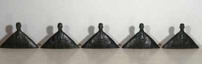 five black plastic bells are lined up in a row on a table