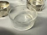 a glass of water sitting on a table next to a metal bowl