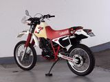 a red and white dirt bike parked in a garage