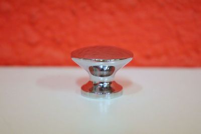 un gros plan sur un bouton métallique posé sur une table blanche
