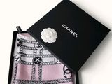 a black box with a pink scarf and a white flower