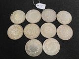 six silver coins are arranged in a circle on a black surface
