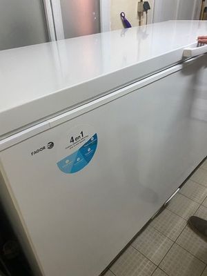 un homme debout à côté d'un réfrigérateur blanc dans une cuisine