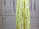 a yellow dress on a mannequin stand in a room