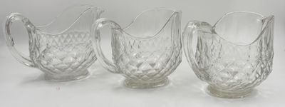 trois pichets en verre transparent posés sur une table blanche