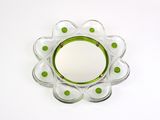 a glass plate with green dots on it on a white surface