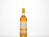 une bouteille de vin posée sur une table à côté d'un mur blanc