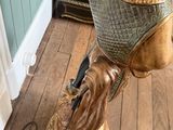 a statue of a man riding a bike on a wooden floor