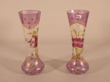 two vases with flowers painted on them on a table
