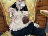 a doll that is sitting on a chair in a room