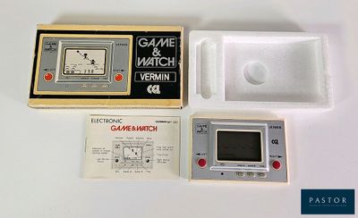 une console Game & Watch dans une boîte, à côté d'une manette de jeu
