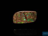 un gros plan d'une bague sertie d'oplite verte et rouge