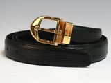 Gros plan sur une ceinture noire avec une boucle dorée