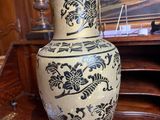 a large vase sitting on a table in front of a painting