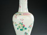 un vase blanc avec des fleurs et des oiseaux peints dessus
