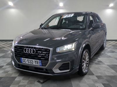 L'Audi QX est garée sur un sol à damier dans un garage.