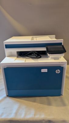 une imprimante bleue et blanche posée sur une table blanche