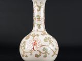 une image représentant un vase blanc orné de motifs verts et rouges