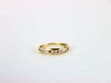 a close up of a diamond ring on a white surface