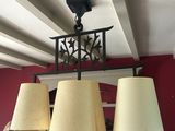 un homme debout devant un lustre muni de trois lampes