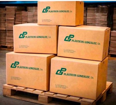 des cartons empilés sur une palette dans un entrepôt, avec d'autres palettes en arrière-plan