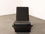 a black chair that is sitting in the corner of a room
