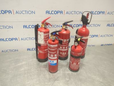 fire extinguisors are lined up on a table in front of a wall