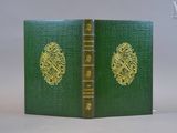 un vieux livre à la couverture verte posé sur une table