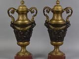 paire de vases en bronze et noir reposant sur des socles en marbre rouge