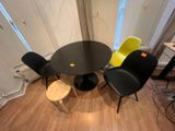 a black table with four yellow chairs and a black table with four yellow chairs