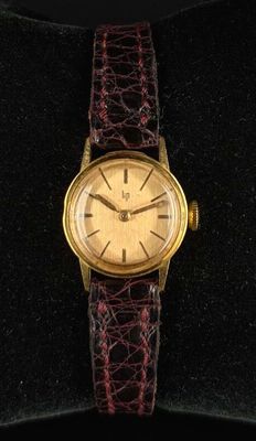 an image of a gold plated wrist watch on a velvet case