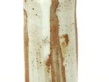 a brown and white vase sitting on a white surface