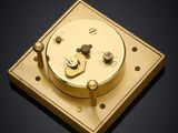 an image of a gold clock on a black surface