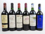 six bouteilles de vin sont alignées sur une surface blanche