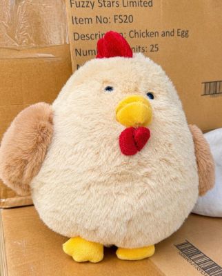 un poulet en peluche posé sur une boîte en carton