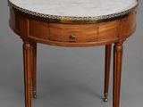 une table ronde avec un plateau en marbre et des pieds en bois