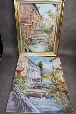 deux tableaux encadrés représentant une rivière et un bâtiment, posés sur une table