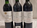 trois bouteilles de vin rouge sont alignées sur une table