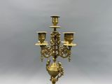 an antique brass candelabra with five candles on a marble base
