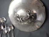 a silver plate with spoons and spoons on a table