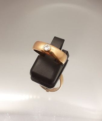 une bague en or sertie d'un diamant posée sur un téléphone portable