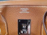 a close up of a brown purse with a metal handle