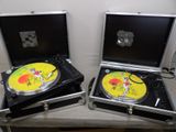 deux platines avec des disques vinyles dans leurs pochettes, posées sur une table